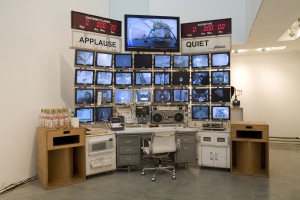 Mission Control. Notice the liquor bottles and ovens and applause and quiet signs. This component of the piece plays with the idea that we only know about NASA's space exploration through television.