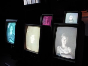 Sarah O'Donnell, Untitled video installation. The tvs are on their sides and "sitting" in seats.