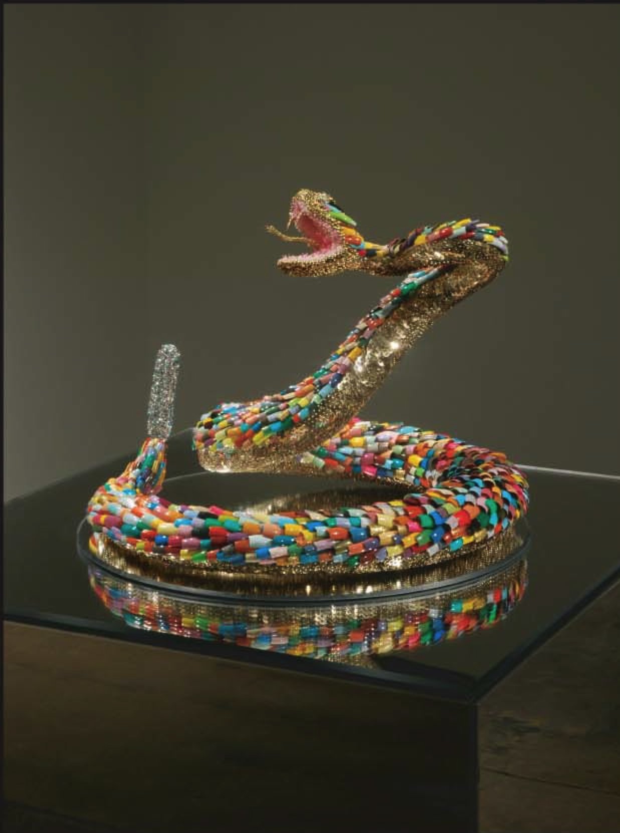 A sculpture of a snake with its body coiled and its mouth open as if to strike.